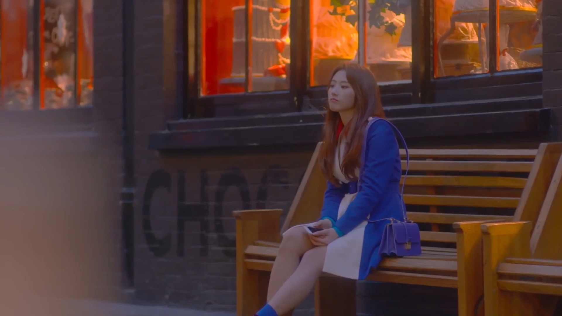 Haseul sitting on a bench.